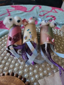 dragon heads made from decorated toilet paper rolls with cotton ball eyes